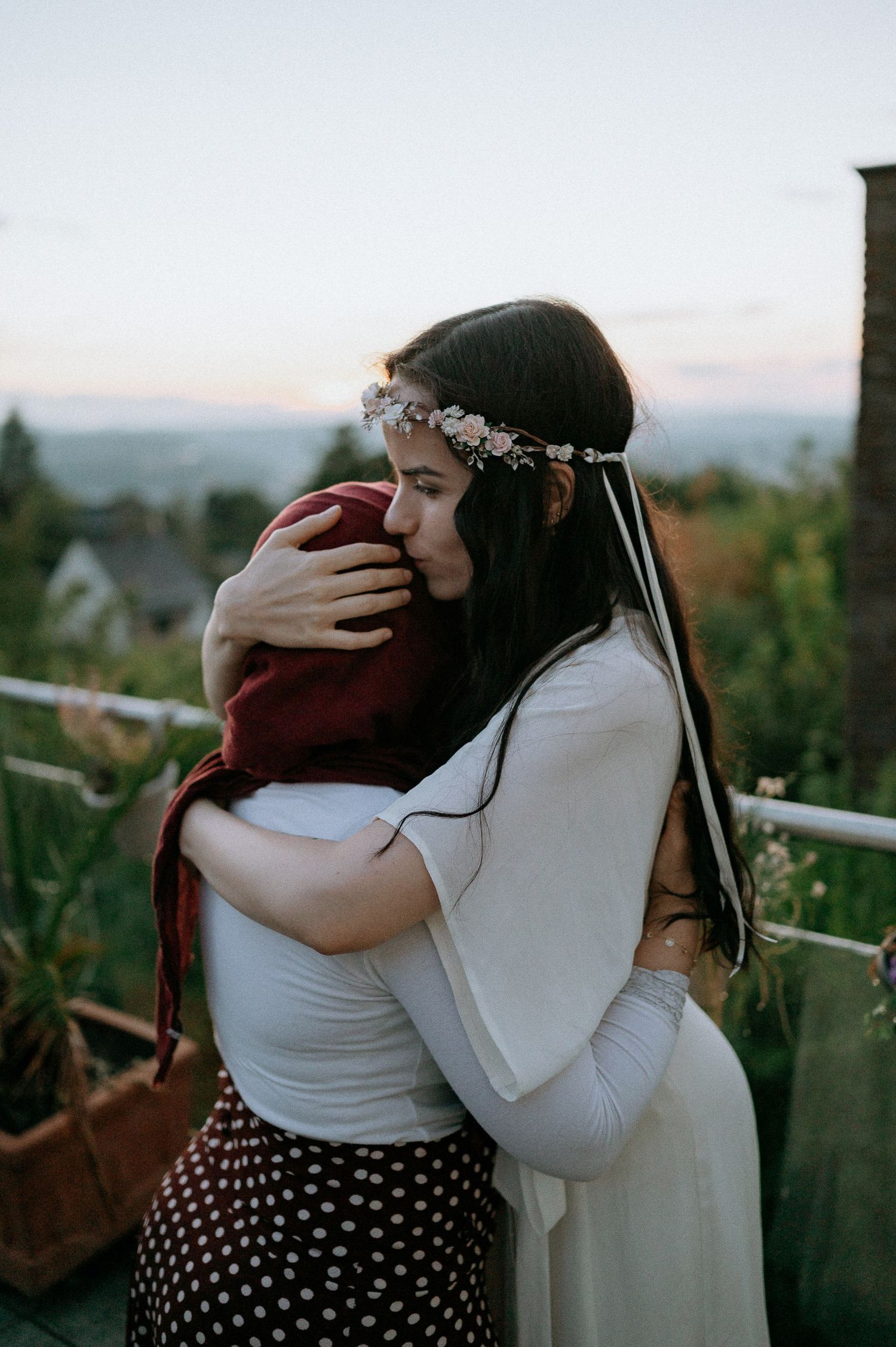 Emotional embraces captured at sunset with mountains in the background.