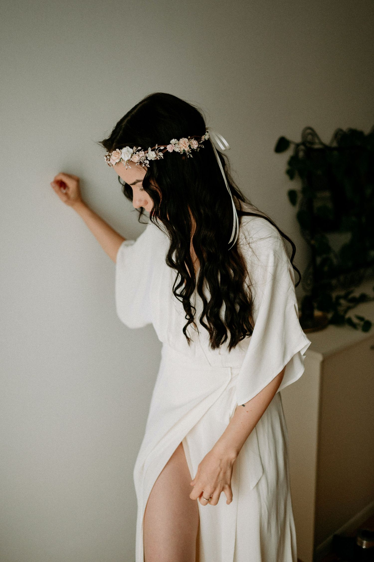 Artistic movement shots in flowing white garments against minimal wall.