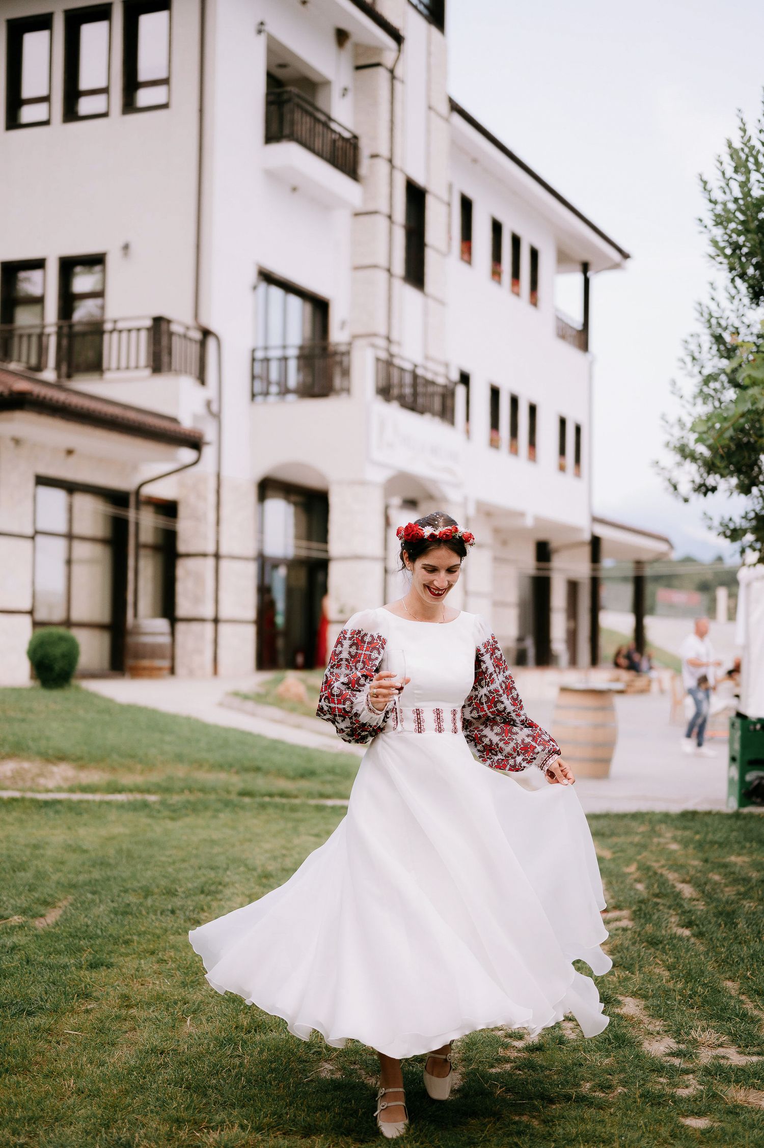 Spinning dance movements in white traditional dress outside modern building.
