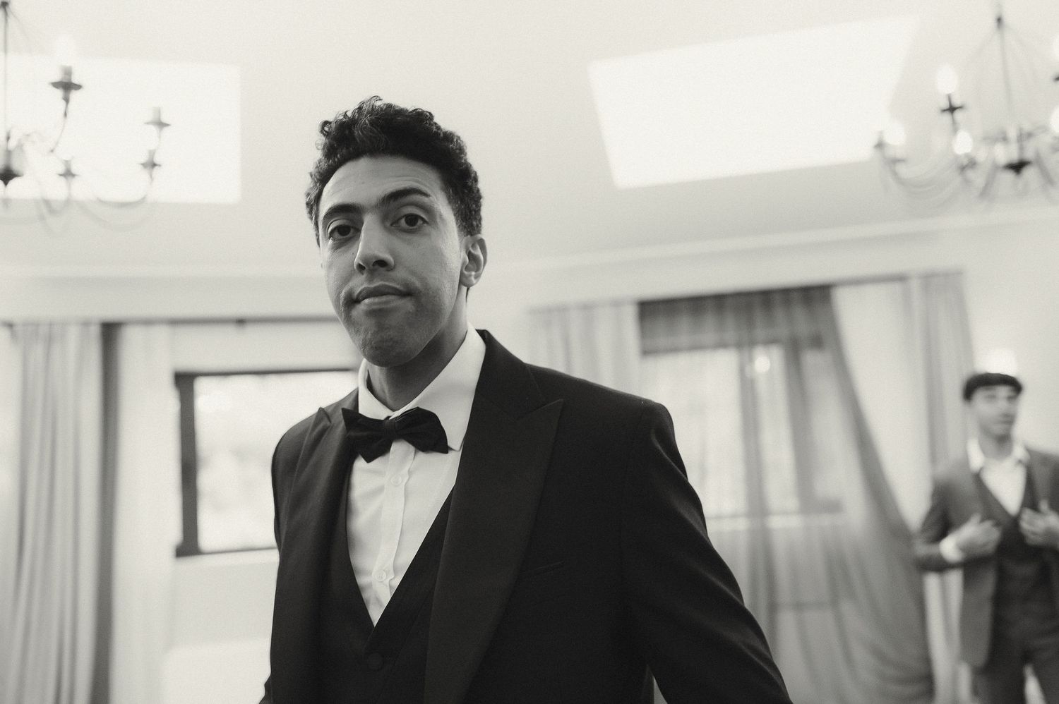Black and white photograph of formal attire preparations in an elegant room.