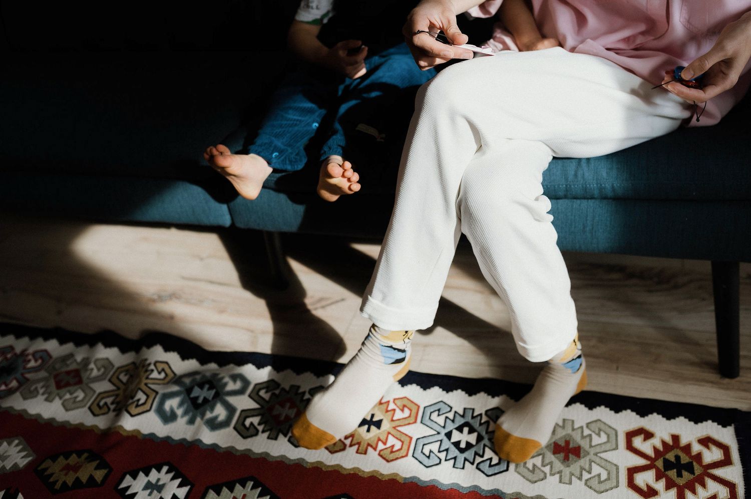 Feet of a couple dancing together on a patterned rug during what appears to be a wedding celebration.