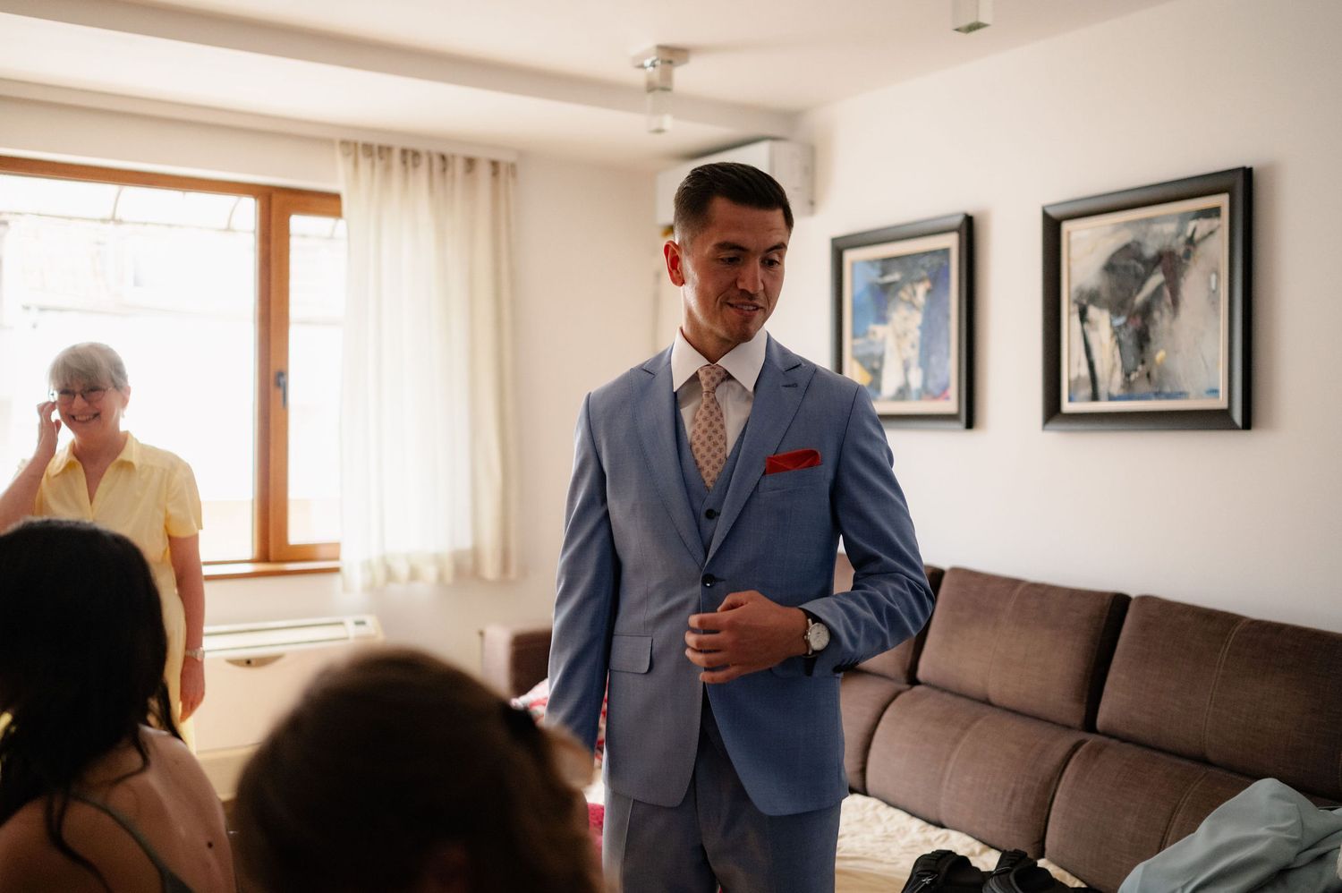 A series of connected photos showing someone in a blue suit looking at papers and sitting on a brown couch.