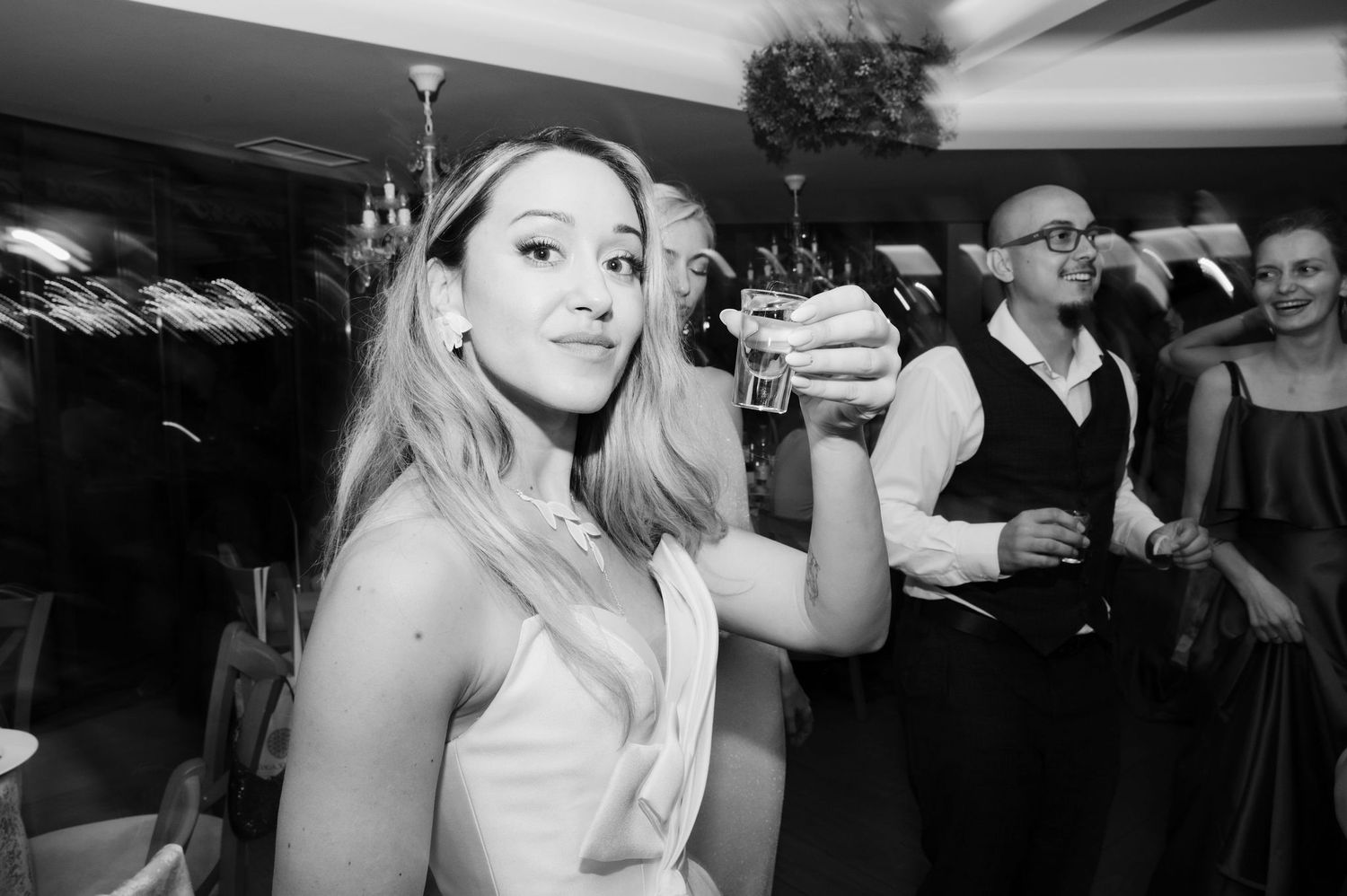 People dancing and celebrating at a lively party in black and white.