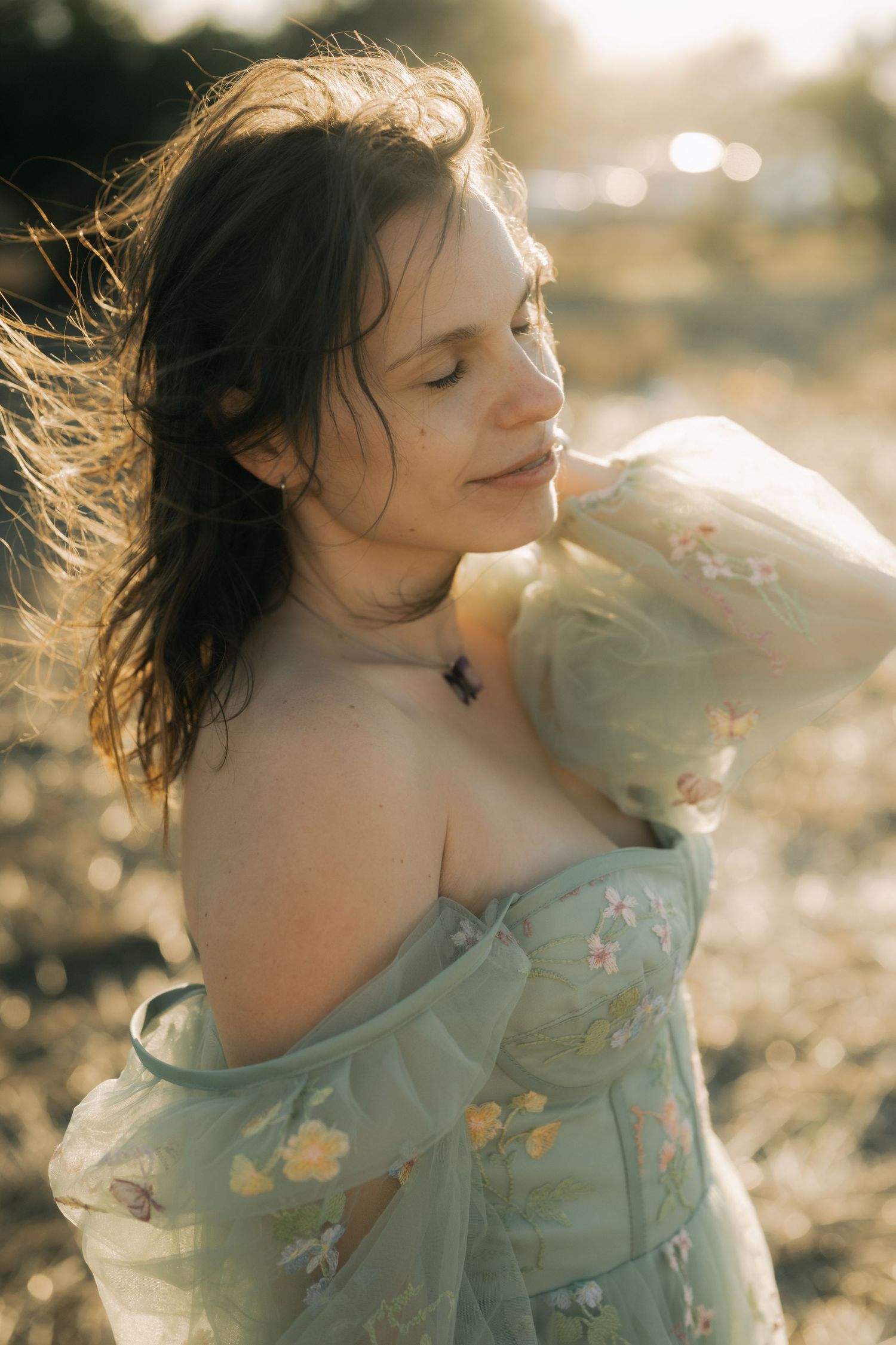 Dreamy sequence of a person in a floral dress with windswept hair posing at golden hour in soft sunlight.