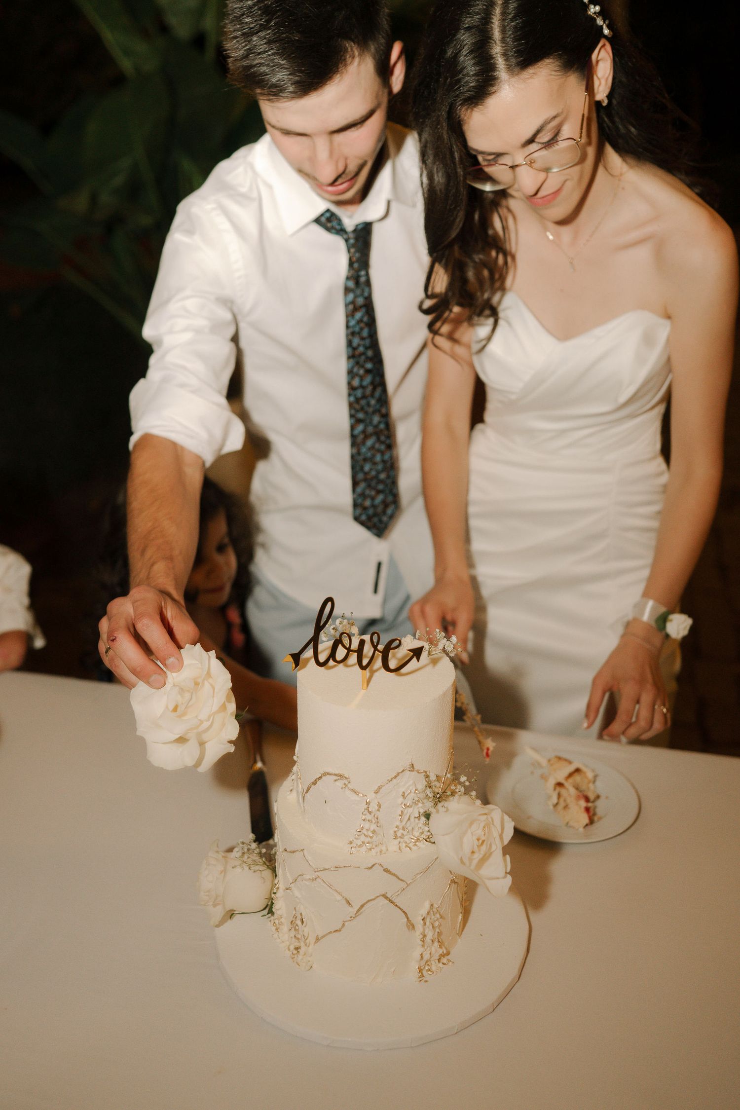 A couple cuts into their wedding cake together in a sequence of candid photos showing the cake-cutting tradition.
