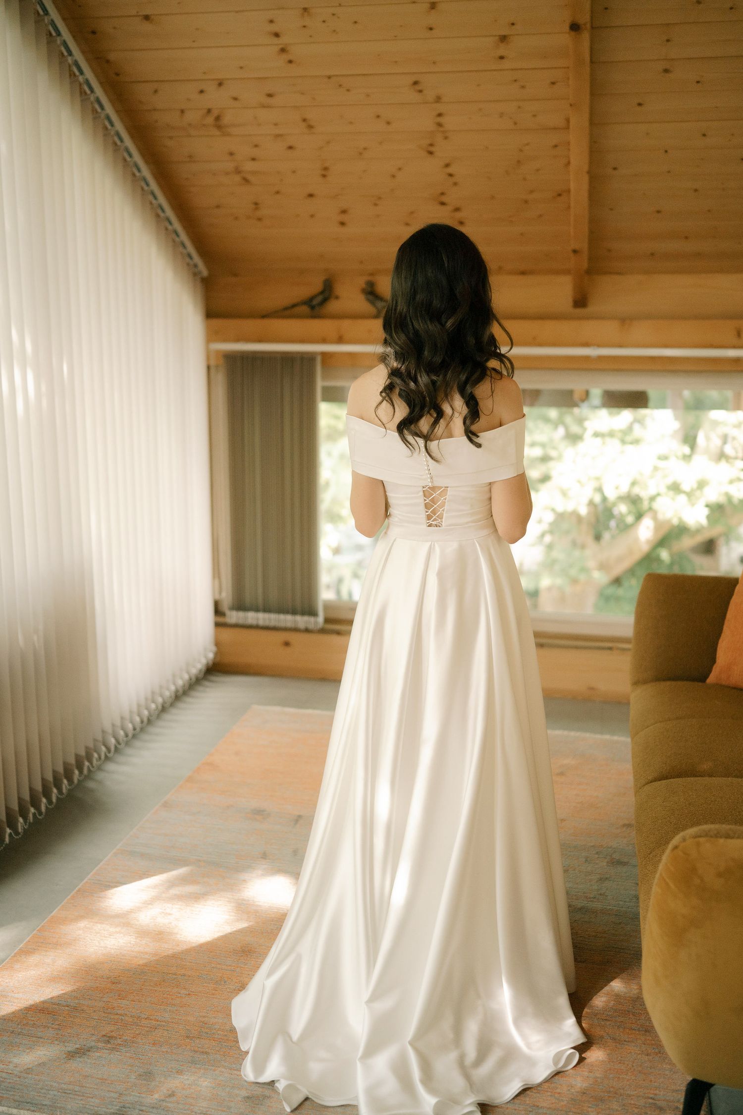 A series of photos showing the back of a white wedding dress in a rustic wooden interior with natural lighting.