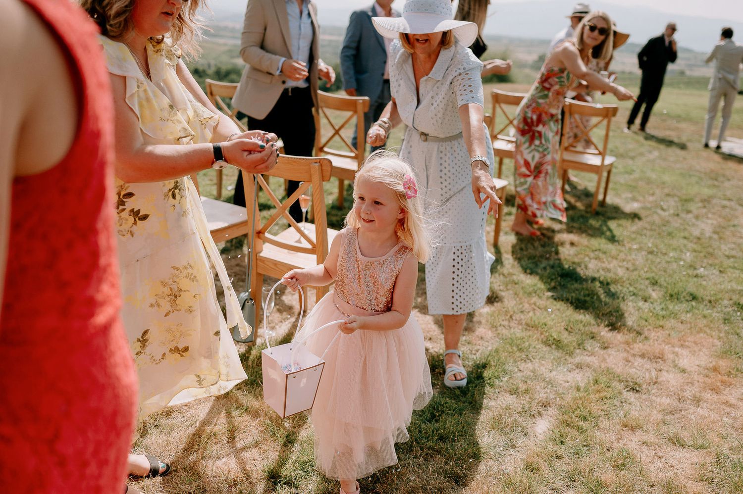 Guests seated in wooden chairs at an outdoor wedding ceremony with scenic mountain views.