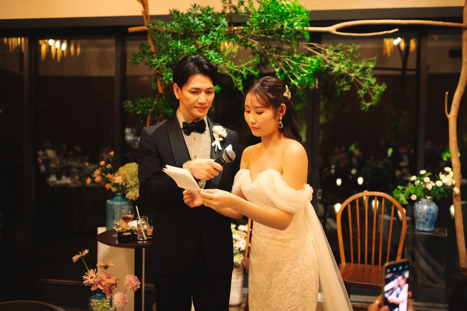 Evening reception with green floral decorations and elegant table settings.