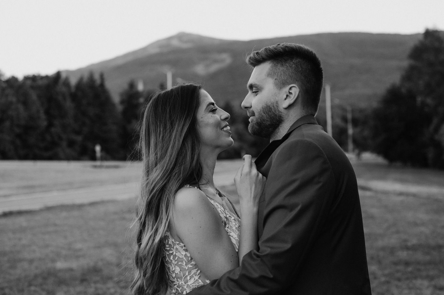 Intimate black and white portrait of a couple against mountain scenery.