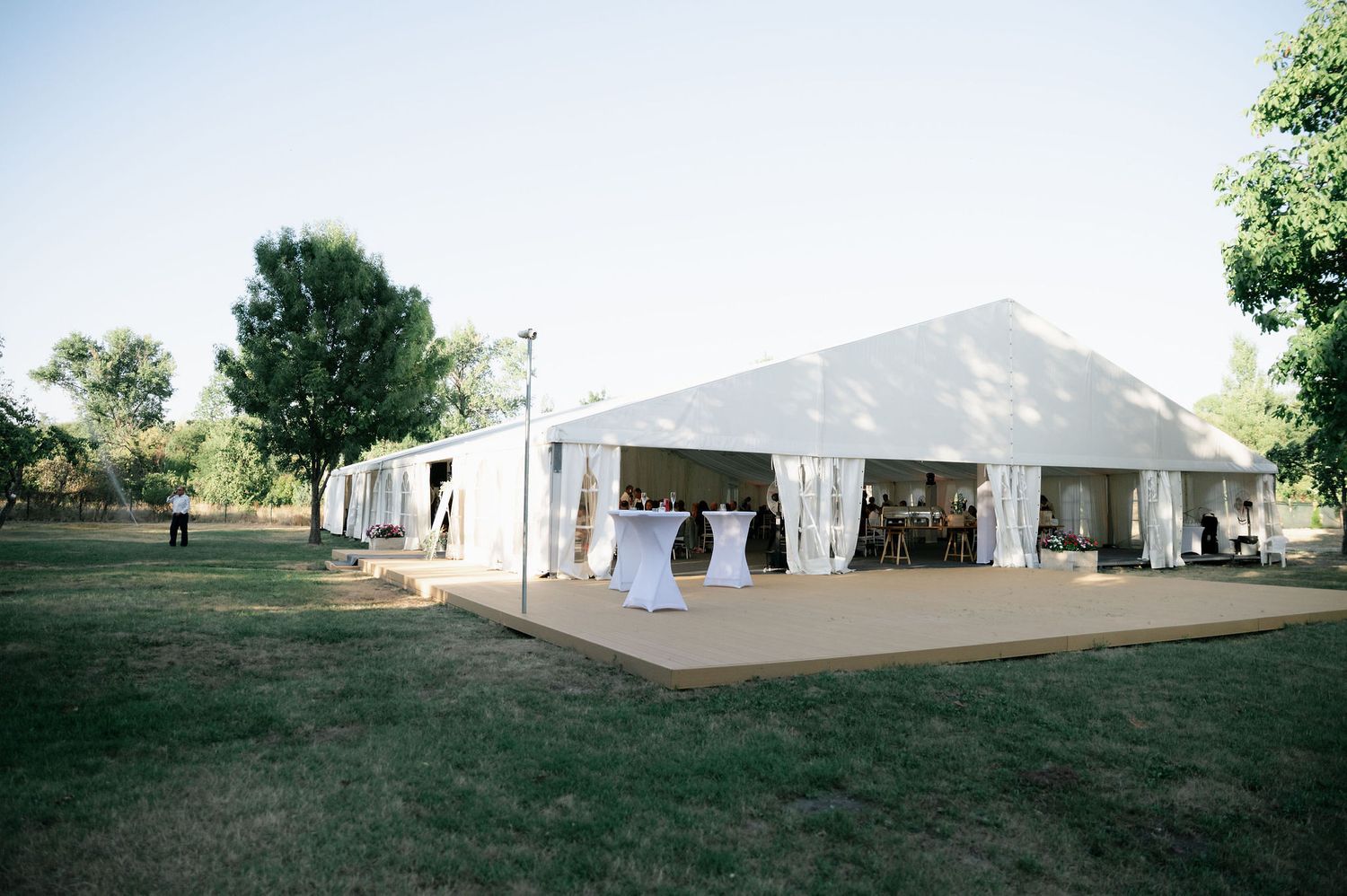 Large white wedding reception tent set up on a grassy outdoor venue.
