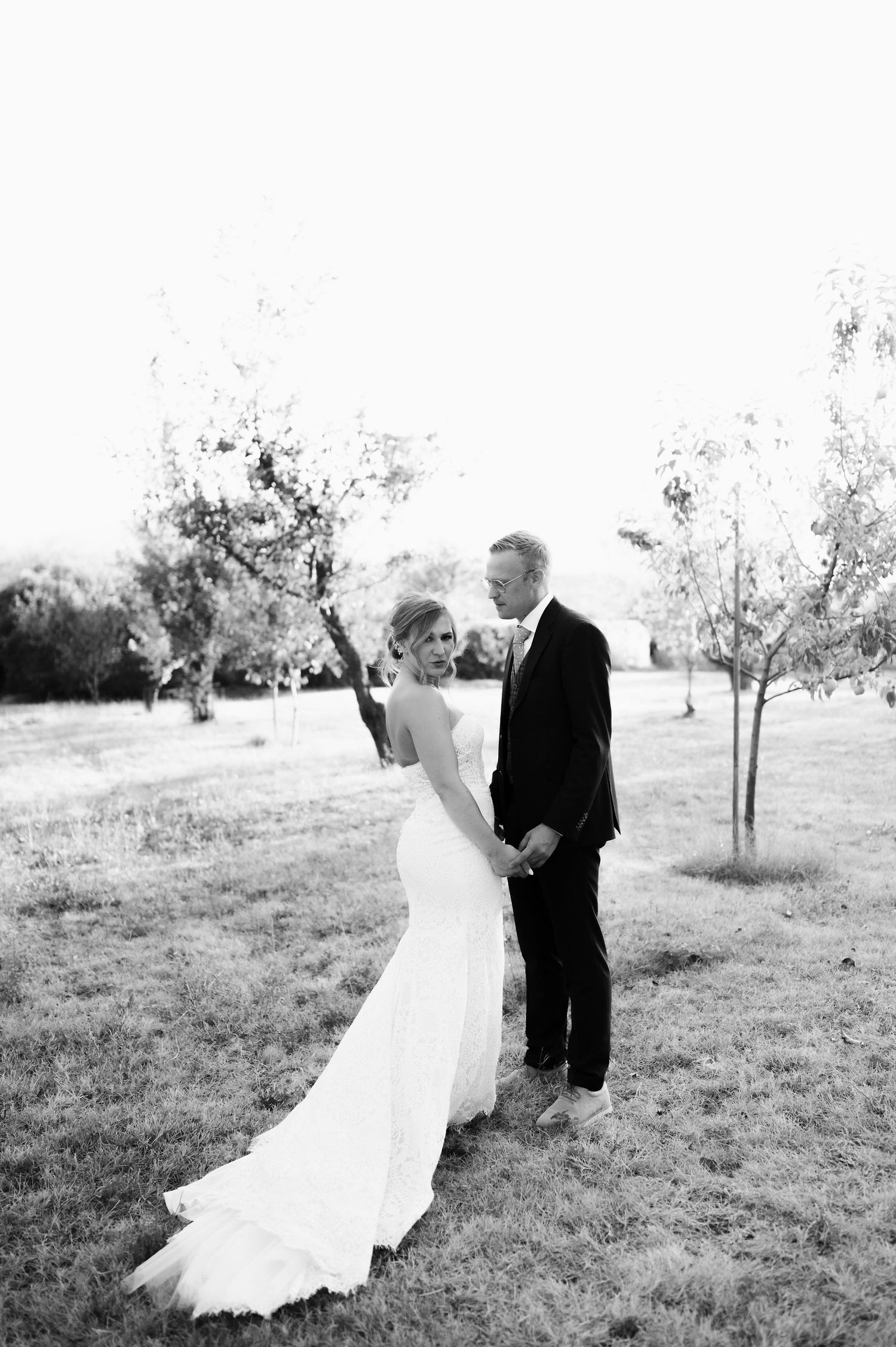 Black and white photos of couple dancing in orchard.