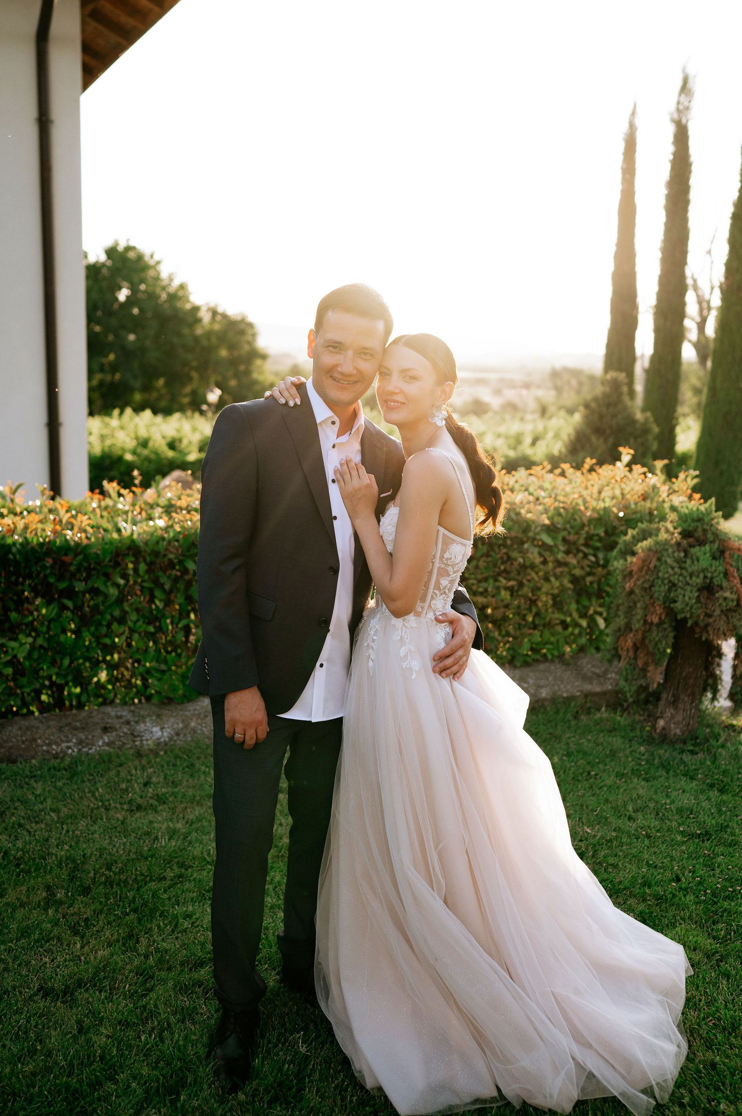 Couple shares playful moments during outdoor wedding photoshoot at golden hour.