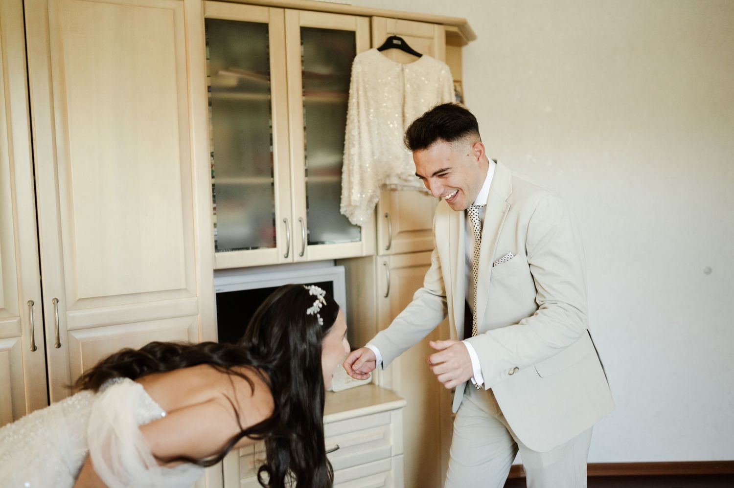 A couple shares a private first look moment in a dressing room.