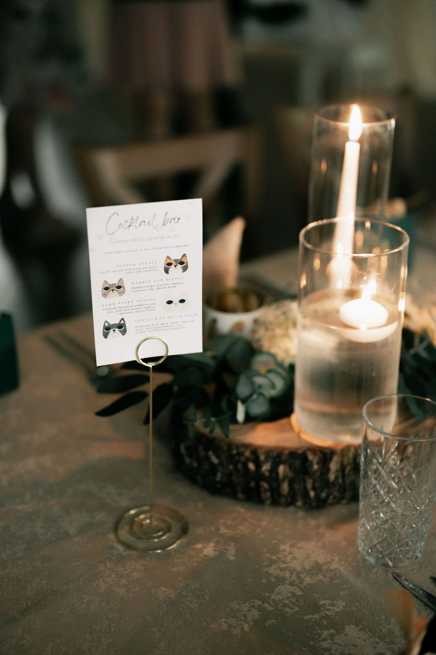 A series of lit candles and place cards create an elegant table setting with a romantic ambiance.