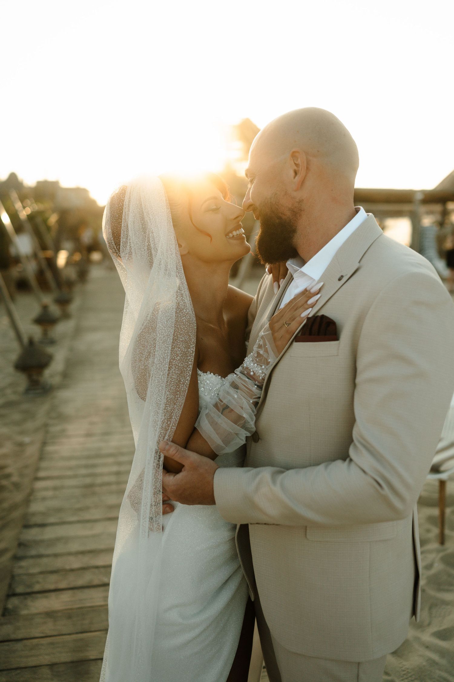 Newlywed couple shares romantic sunset kisses on wooden boardwalk in sequence of intimate wedding photos.