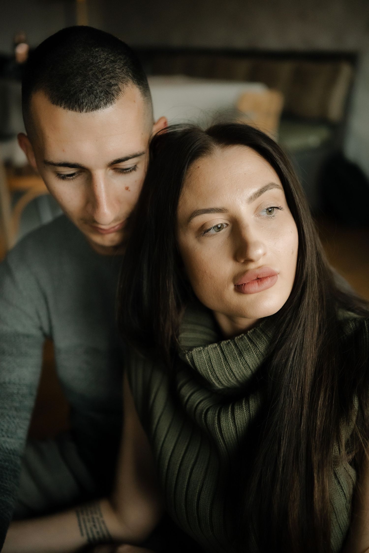 A couple in dark clothing share intimate moments in a dimly lit setting showing affection through five progressive shots.