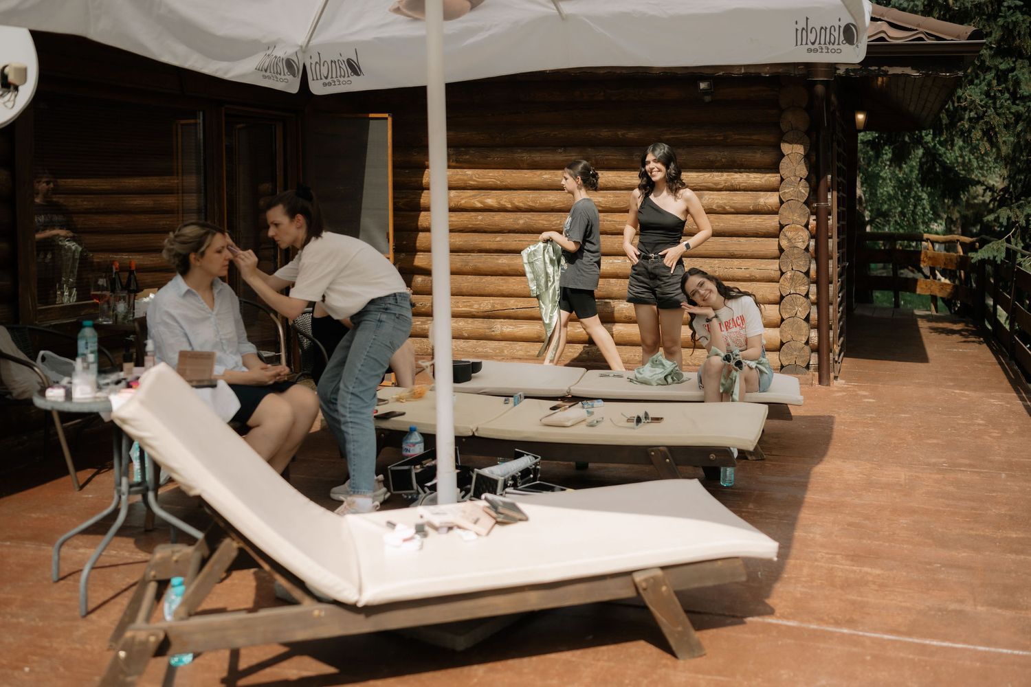 People gather around a wooden picnic table in an outdoor setting to collaborate on a creative project.