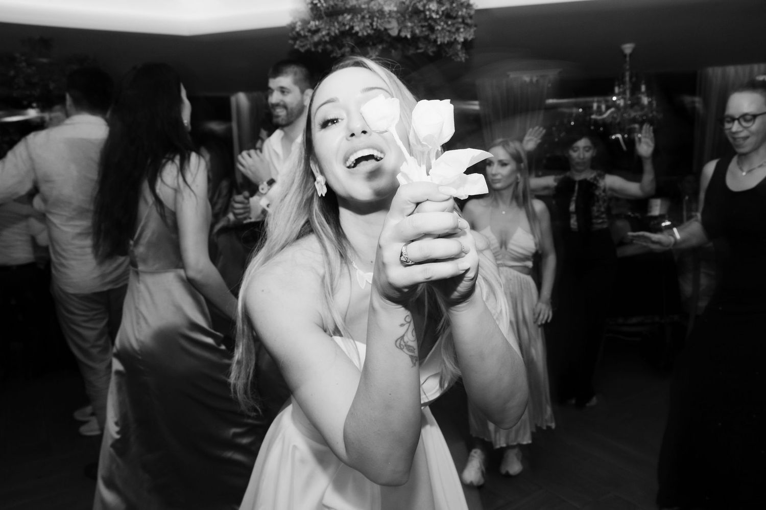 People dancing and celebrating at a lively party or nightclub in black and white photography.