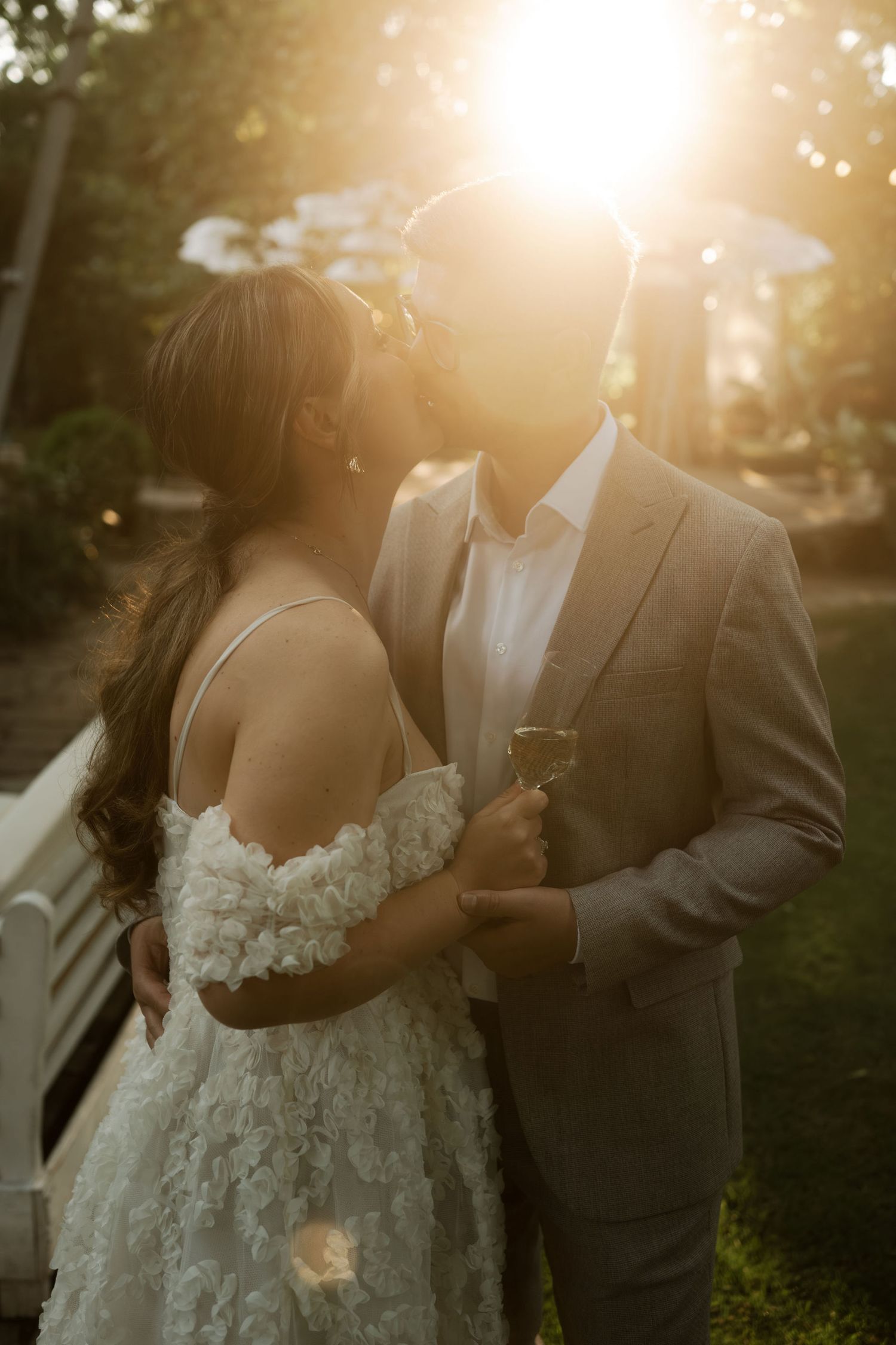 A romantic sunset wedding photo shows a couple embracing outdoors with golden sunlight filtering through trees.