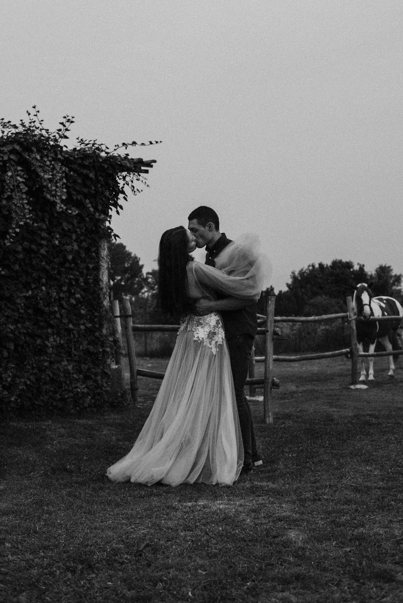 A romantic black and white photo sequence shows a couple embracing in a garden setting with horses in the background.