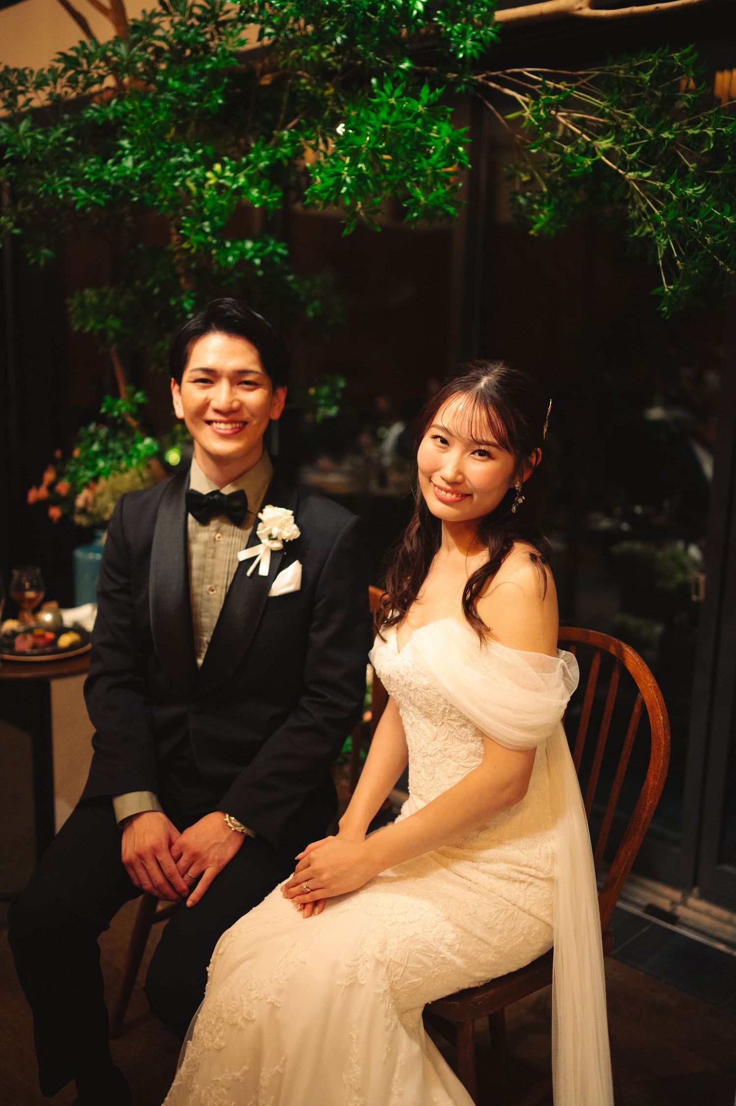 A couple shares a happy moment during their wedding reception under green lighting.