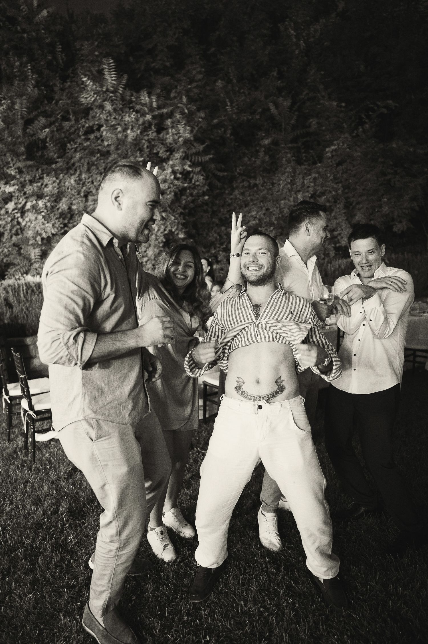 Wedding guests dancing and celebrating together at an outdoor evening reception.