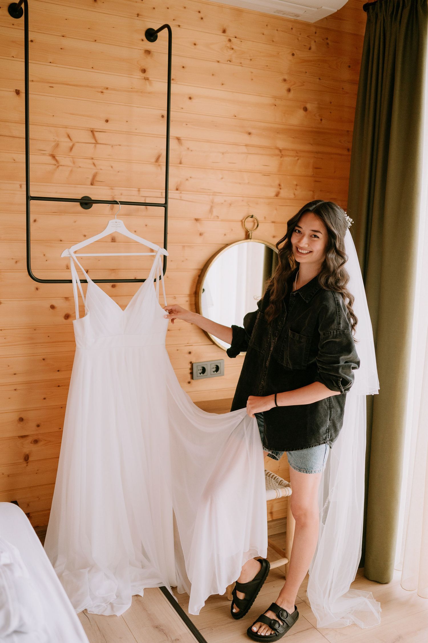 White wedding dresses hanging on display in wooden cabin room.