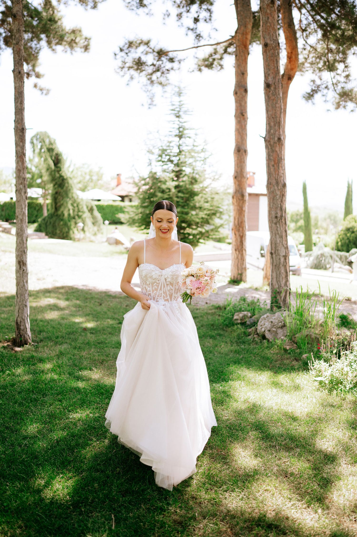 Wedding ceremony setup in a pine forest with sunlight filtering through the trees.