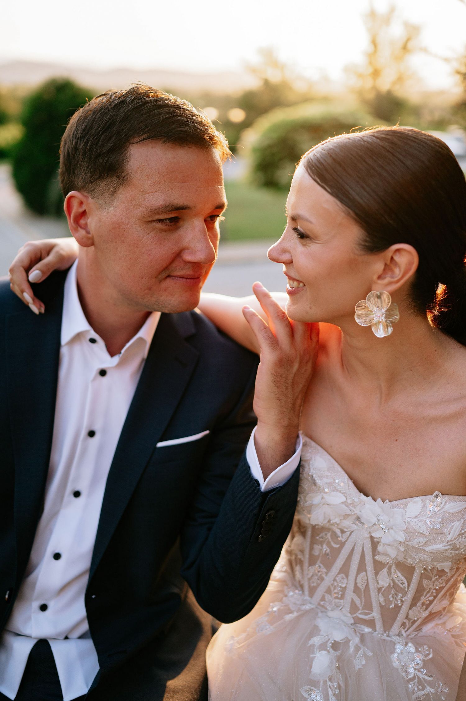 Romantic sunset wedding portraits show tender moments between newlyweds in formal attire.