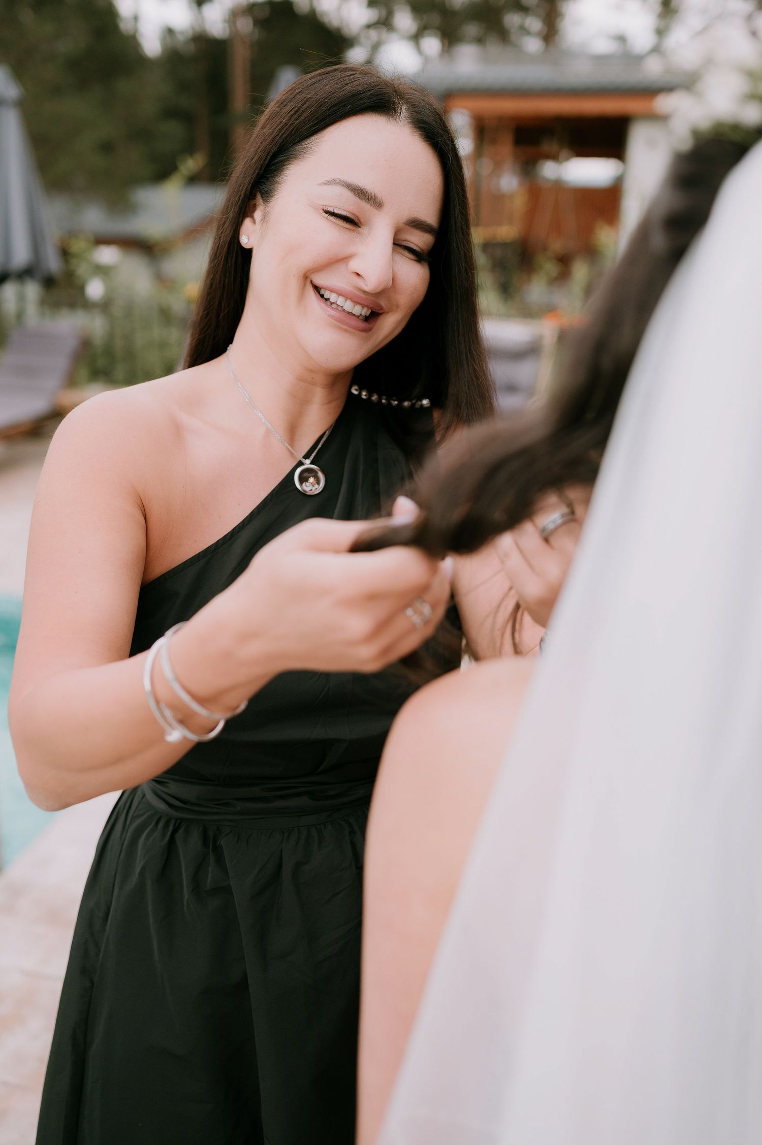 Candid moments shared between two people in black and white attire by a poolside.