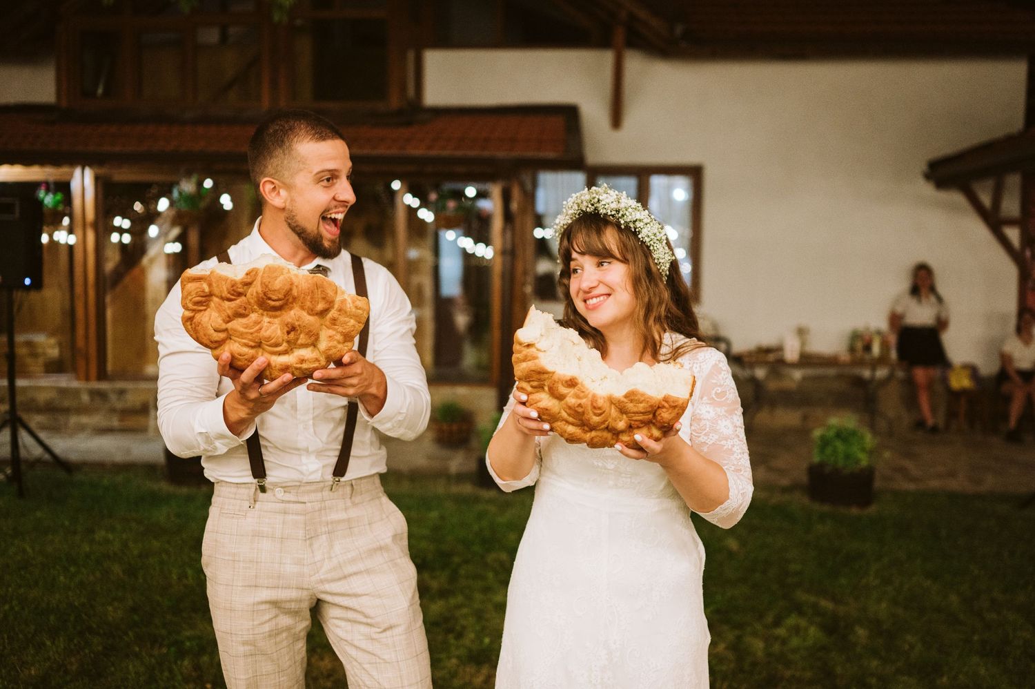 A couple shares a playful moment with funnel cakes at their wedding reception.