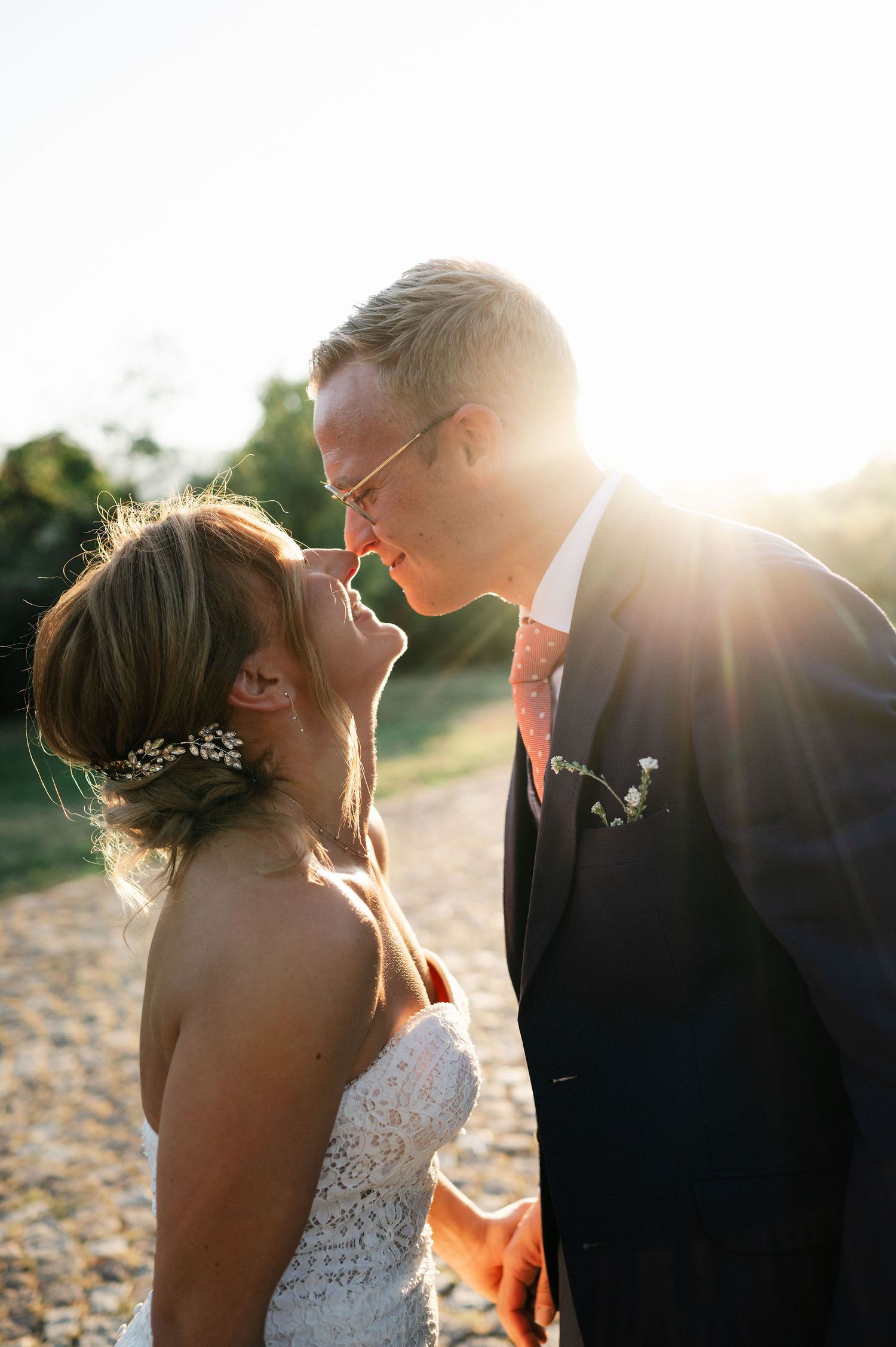 Sunlit wedding portraits showing intimate moments between newlyweds.
