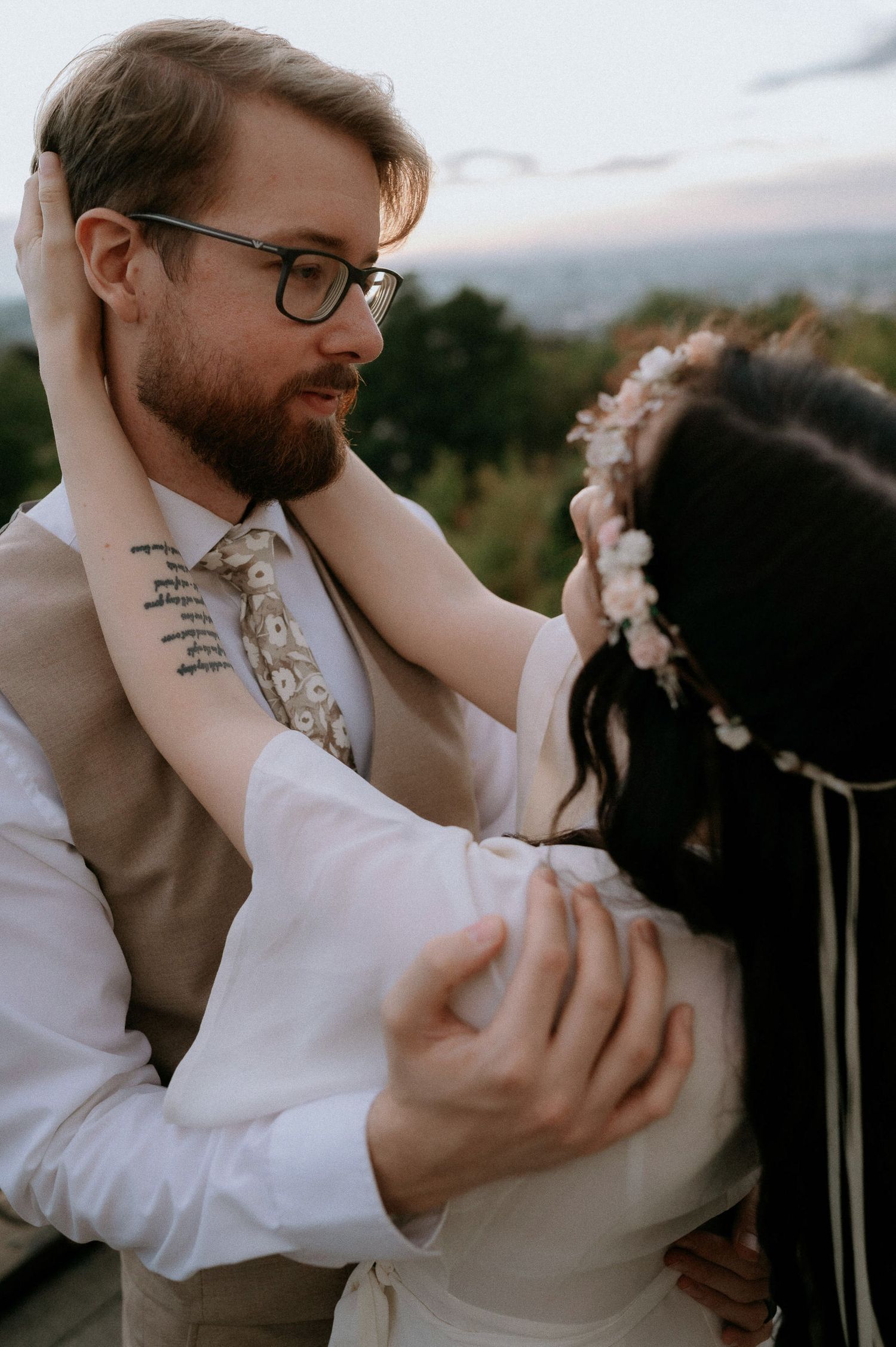 A romantic moment between newlyweds dancing outdoors at dusk.