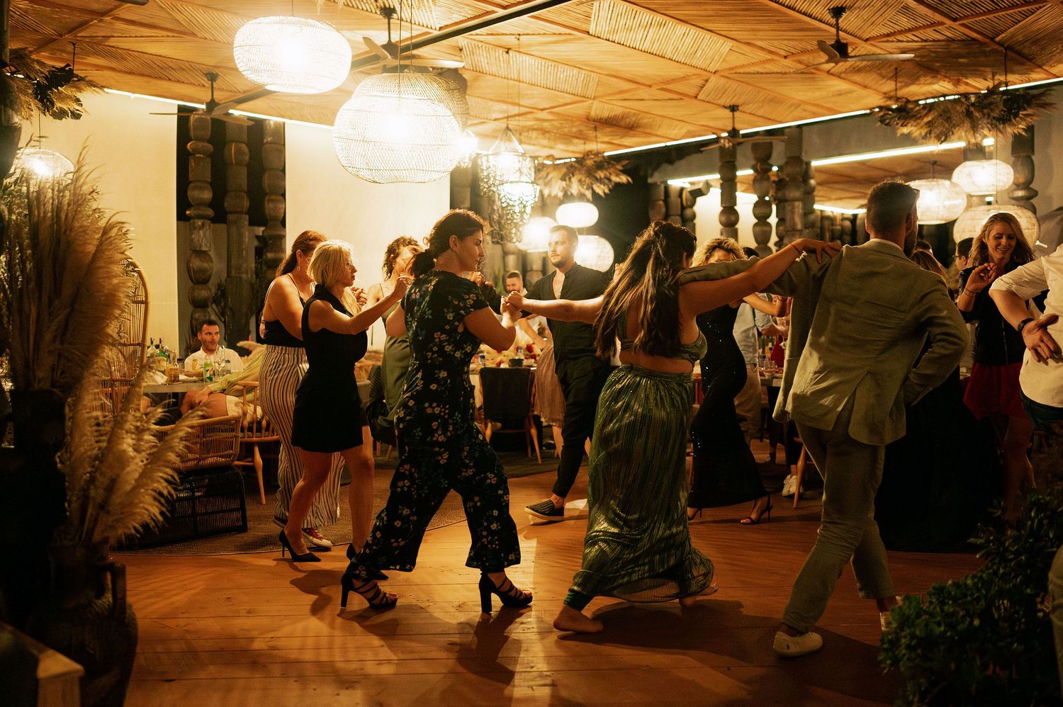 Wedding celebration in rustic indoor venue with warm lighting and dancing guests.
