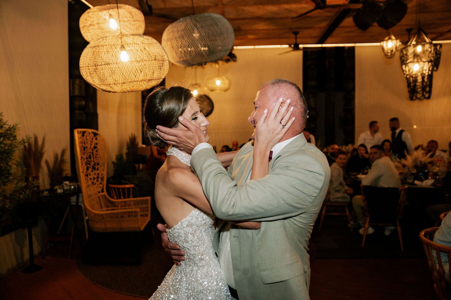 Intimate dance sequence at wedding reception with warm lighting and rattan decor.