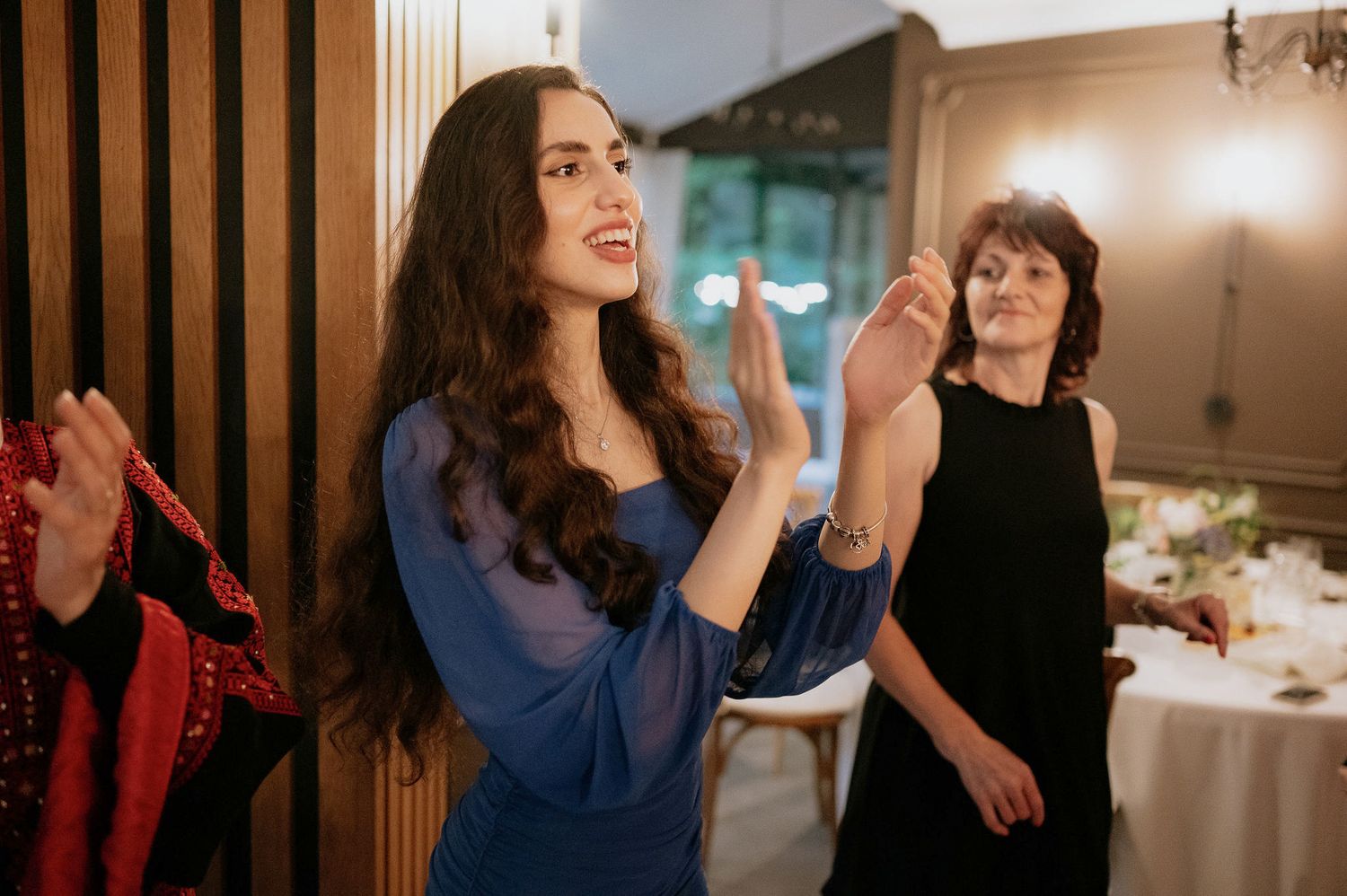 Guests dancing and socializing at an indoor evening celebration.