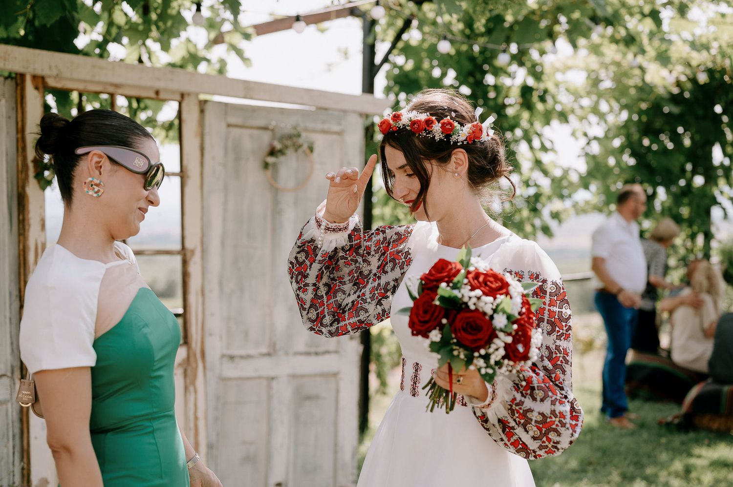 Wedding party members in green dresses and formal attire posing outdoors.