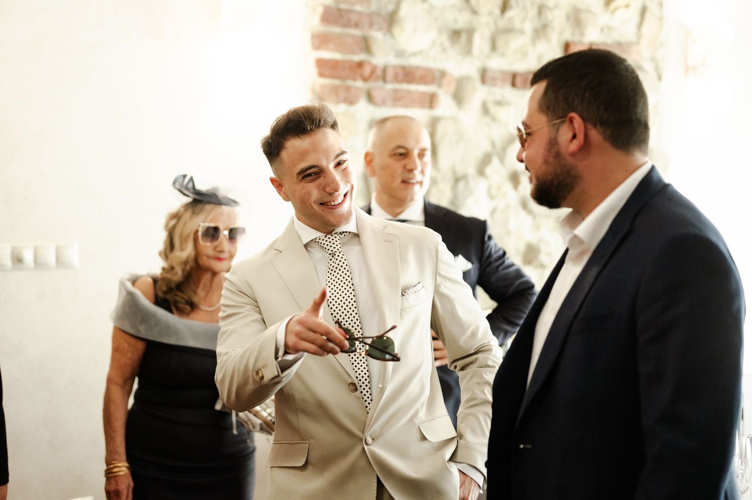 A group sharing a candid moment at a wedding celebration in formal attire.