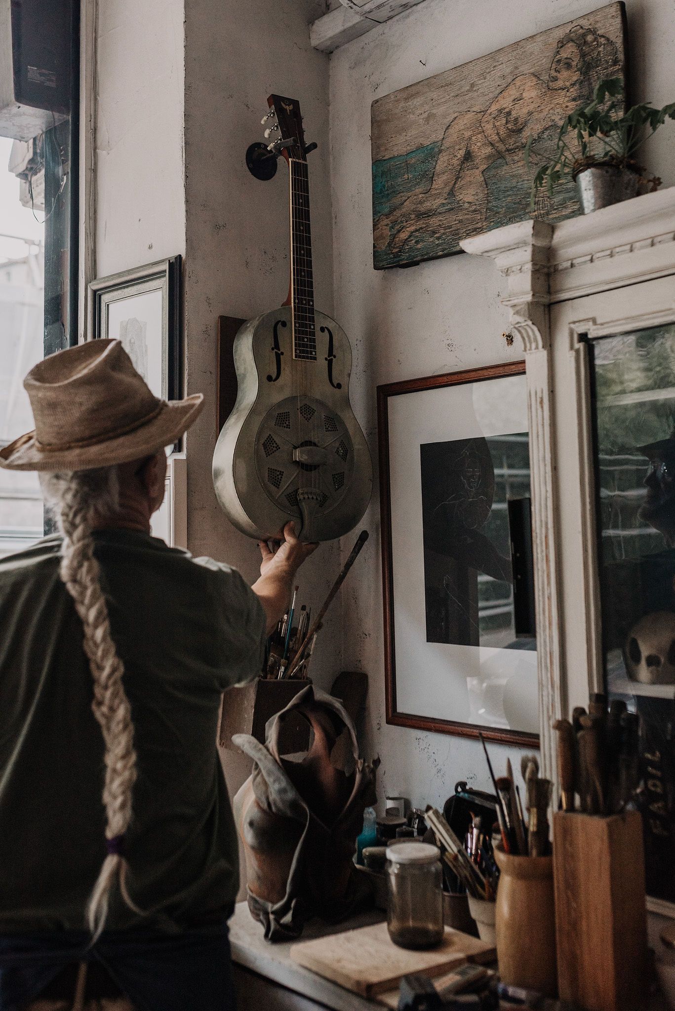 Musical instruments and artwork decorate the walls of a cozy studio space.