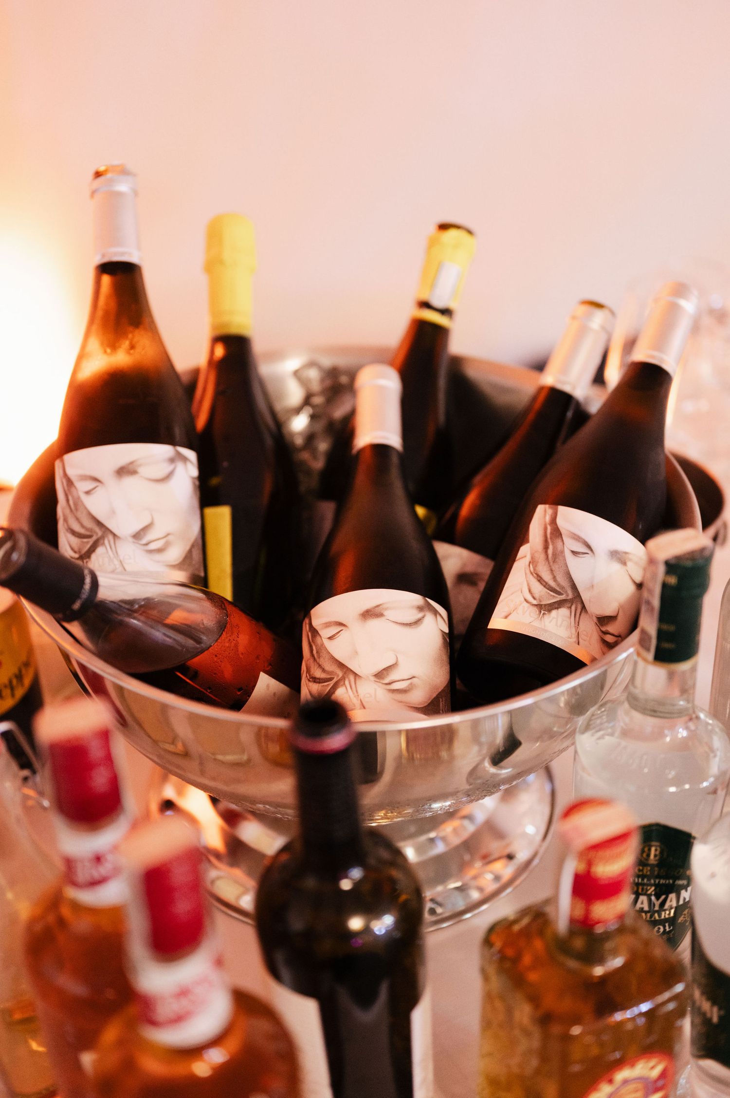 Assorted brown beer and liquor bottles chilling in ice buckets at a party or event.