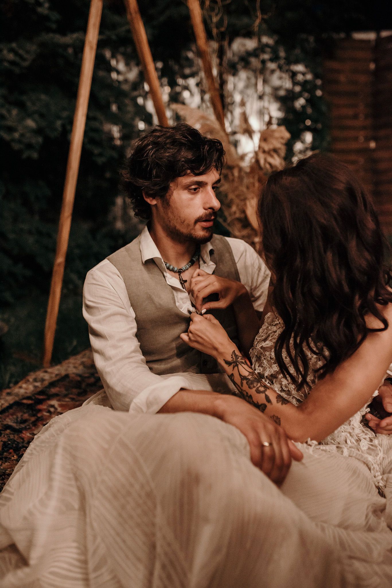 Romantic couple shares intimate moments in a rustic outdoor setting with warm lighting and natural surroundings.