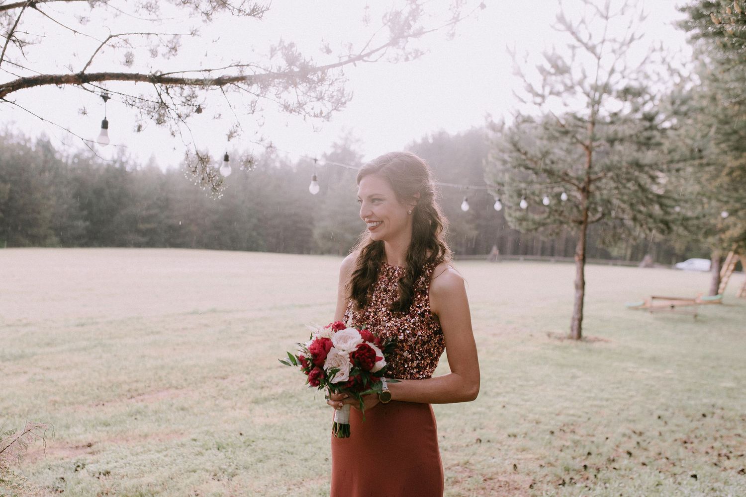 Rustic outdoor wedding scene with white fabric backdrop and mountain views.
