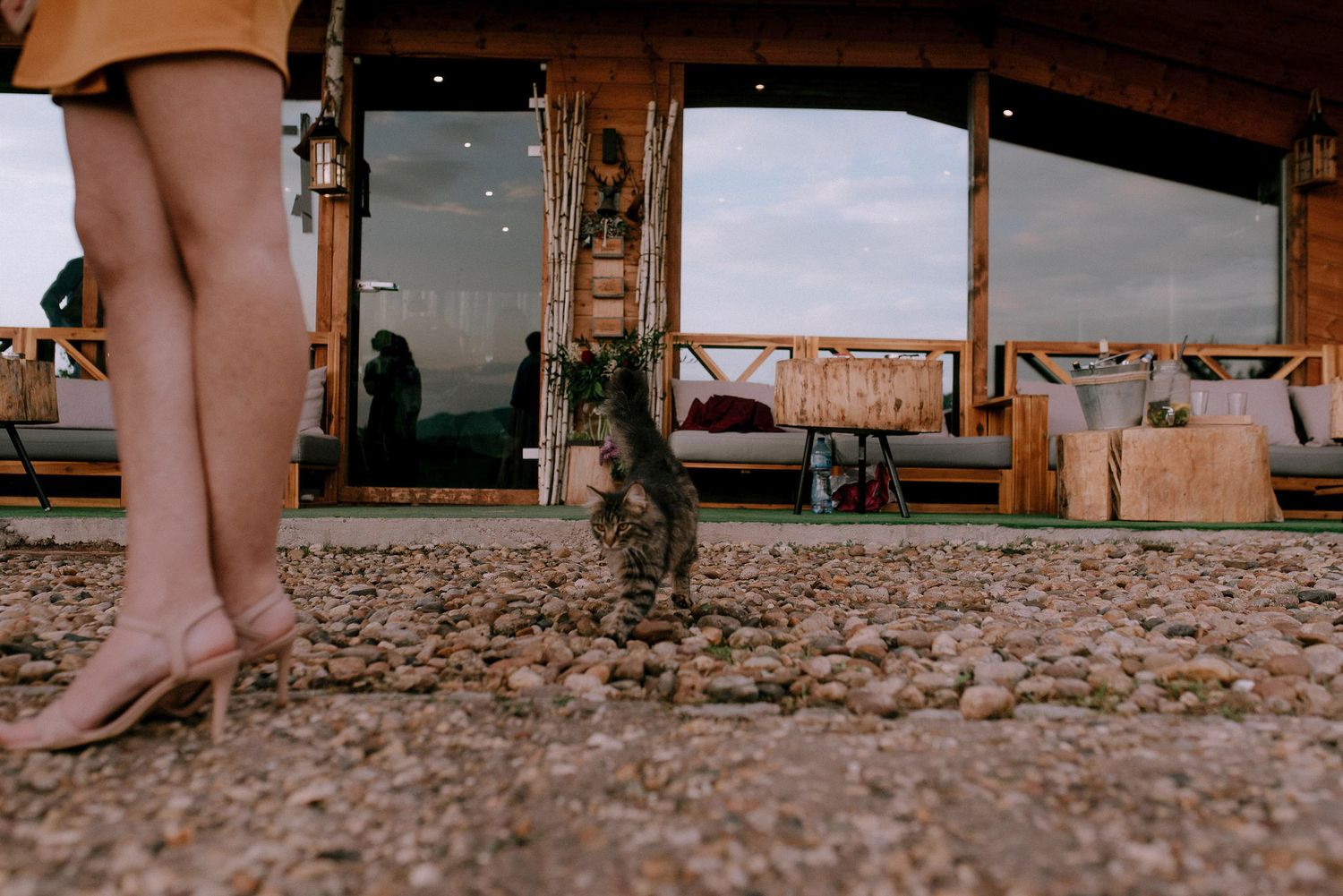Close-up view of feet on a rustic wooden deck or patio floor.