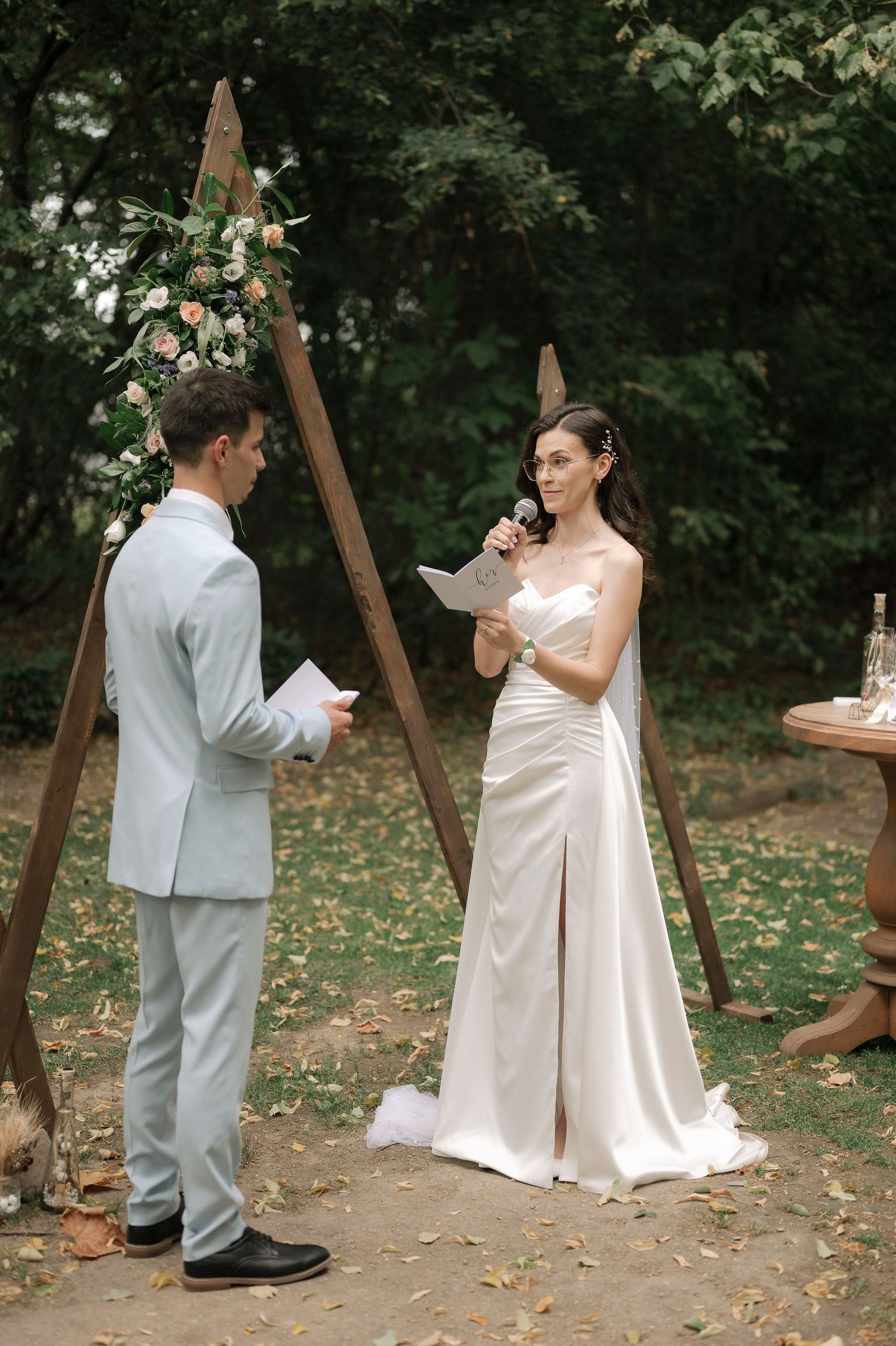 A sequence of candid outdoor wedding photos showing a couple dancing playfully in a wooded setting with fallen leaves.