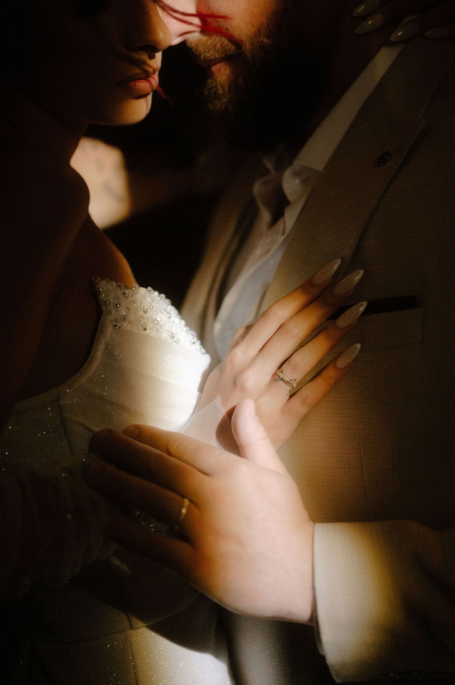 A series of artistic close-up shots showing hands in dramatic lighting against a dark background.
