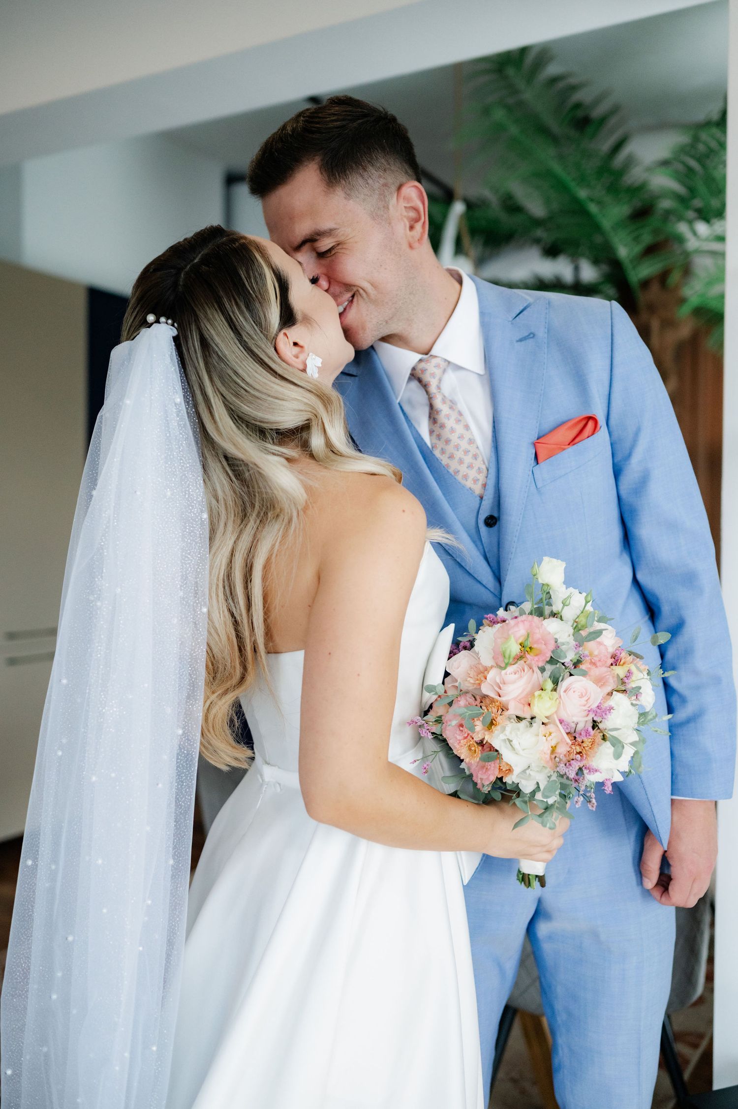 A romantic wedding photo series showing tender moments between newlyweds in light blue suit and white gown with floral bouquet.