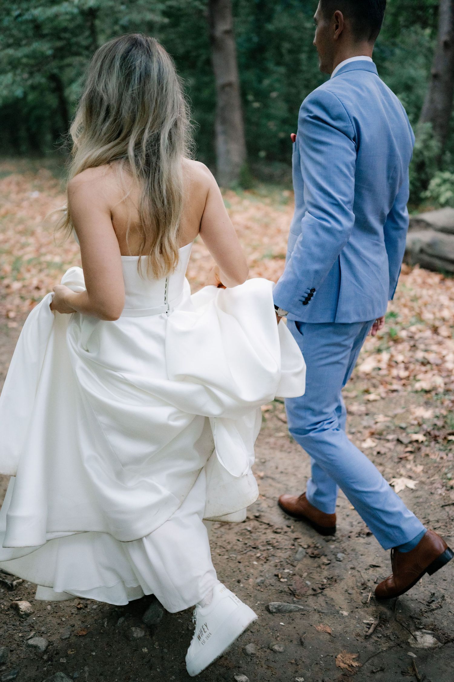 A series of five photos showing white sneakers peeking out under a flowing wedding dress with a blue suited figure.