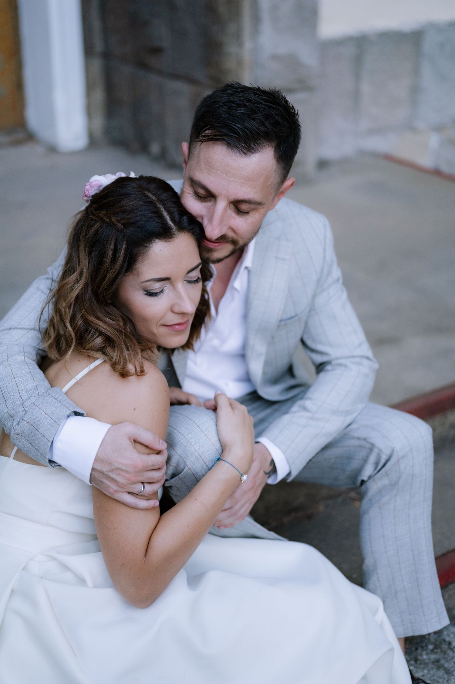 A couple in white and gray attire share intimate moments in a romantic photoshoot series.