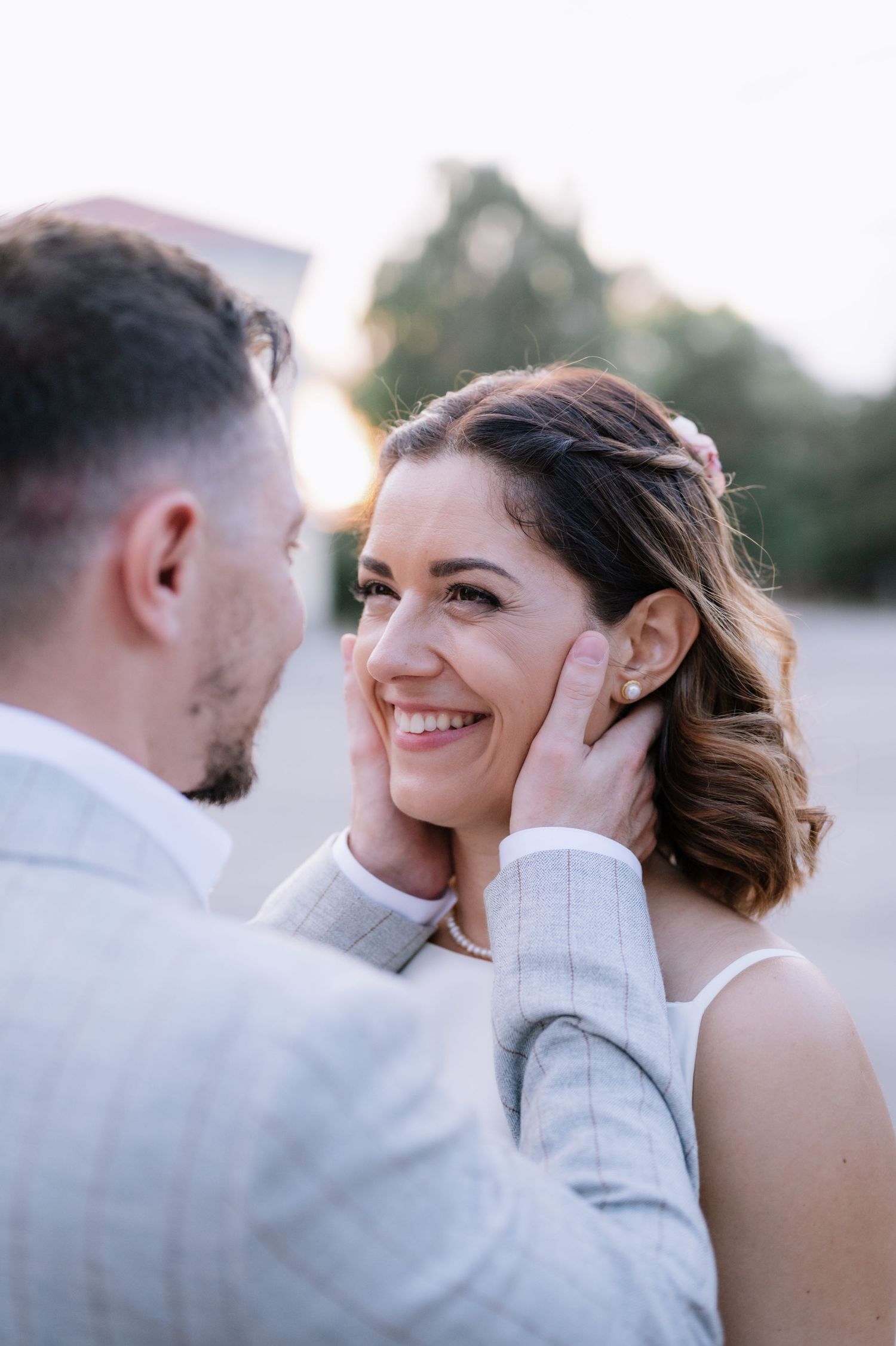 A tender moment between newlyweds during their outdoor wedding photoshoot at sunset.