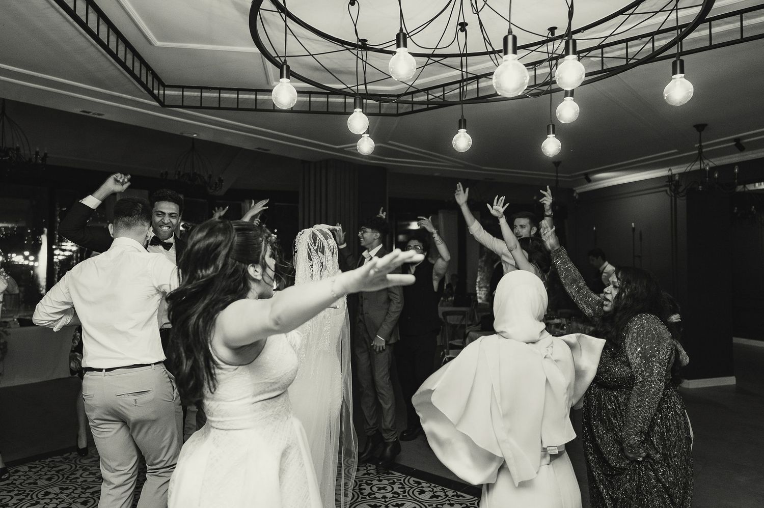 Multiple exposure photo shows dancers creating motion trails under dramatic venue lighting.